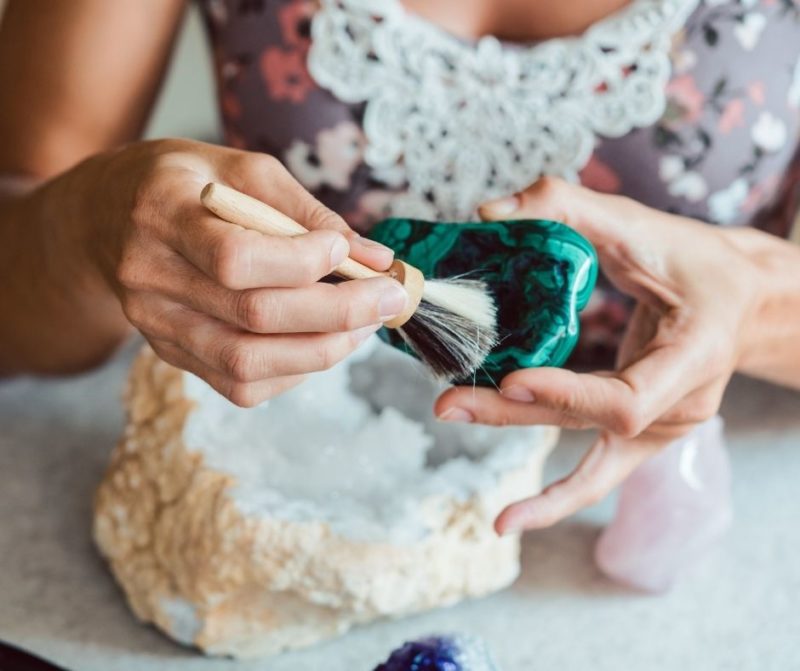 lady cleaning malachite crystal with brush