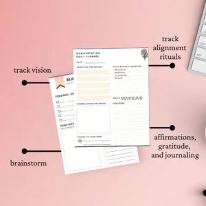 printed manifestation planner on pink desk