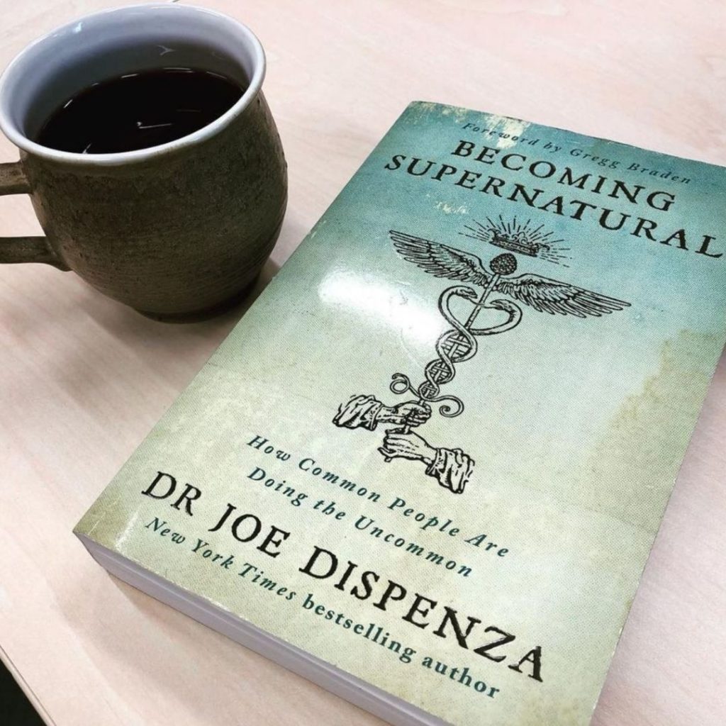 becoming supernatural by joe dispenza on table with tea
